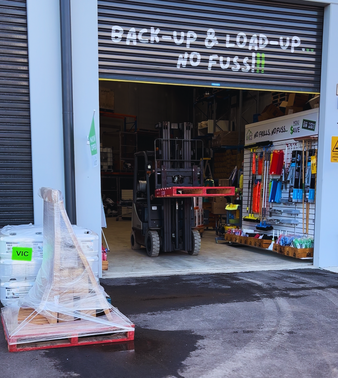 Forklift in a warehouse with 'Back-up & Load-up No Fuss' sign
